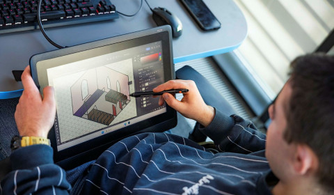 Photograph of a young person using a digital tablet to create and share visual content, highlighting digital creativity, self-expression and the role of technology in communicating ideas and emotions