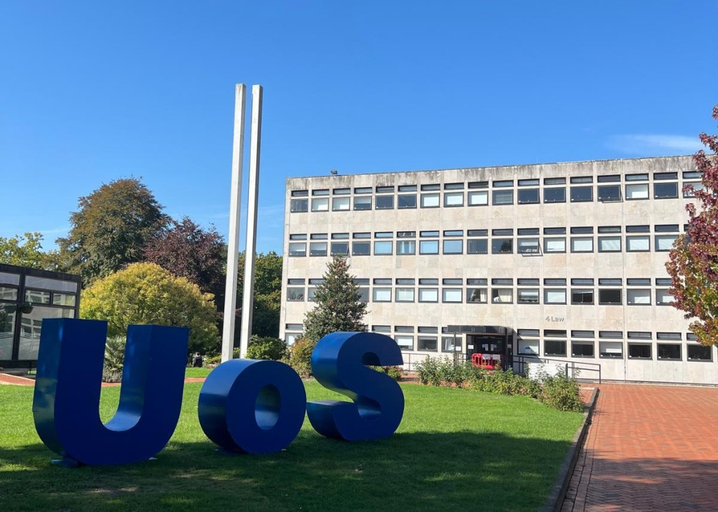 UoS blue sign on grass. Southampton University Campus