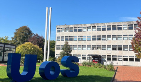 UoS blue sign on grass. Southampton University Campus
