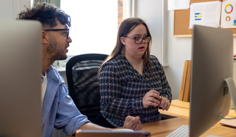 Two people looking at a computer screen.