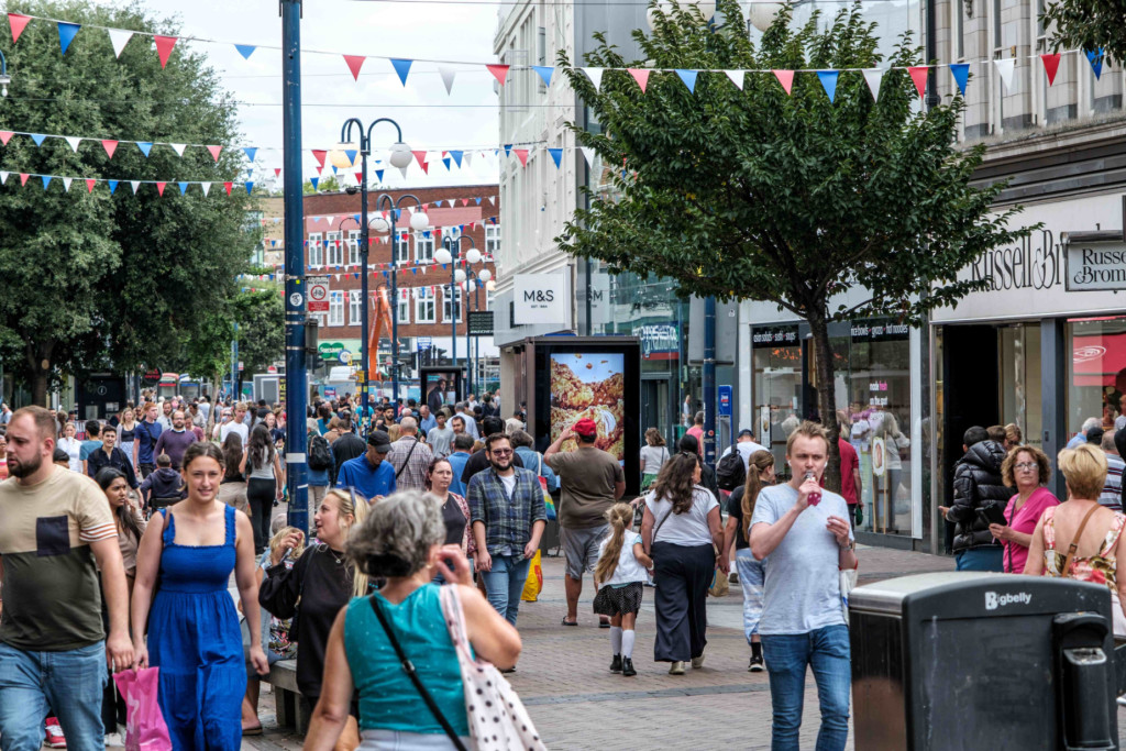 A busy high street filled with people carrying shopping bags. Image courtesy of Shutterstock: Richard M Lee.