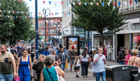 A busy high street filled with people carrying shopping bags. Image courtesy of Shutterstock: Richard M Lee.