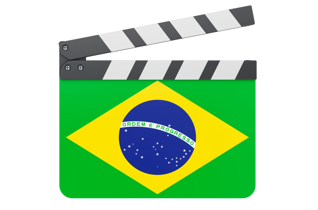 The image is a stylised film clapperboard (director’s slate) featuring the Brazilian flag.