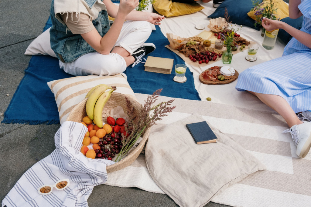 People sharing healthy food outdoors, representing healthy eating and social connection.